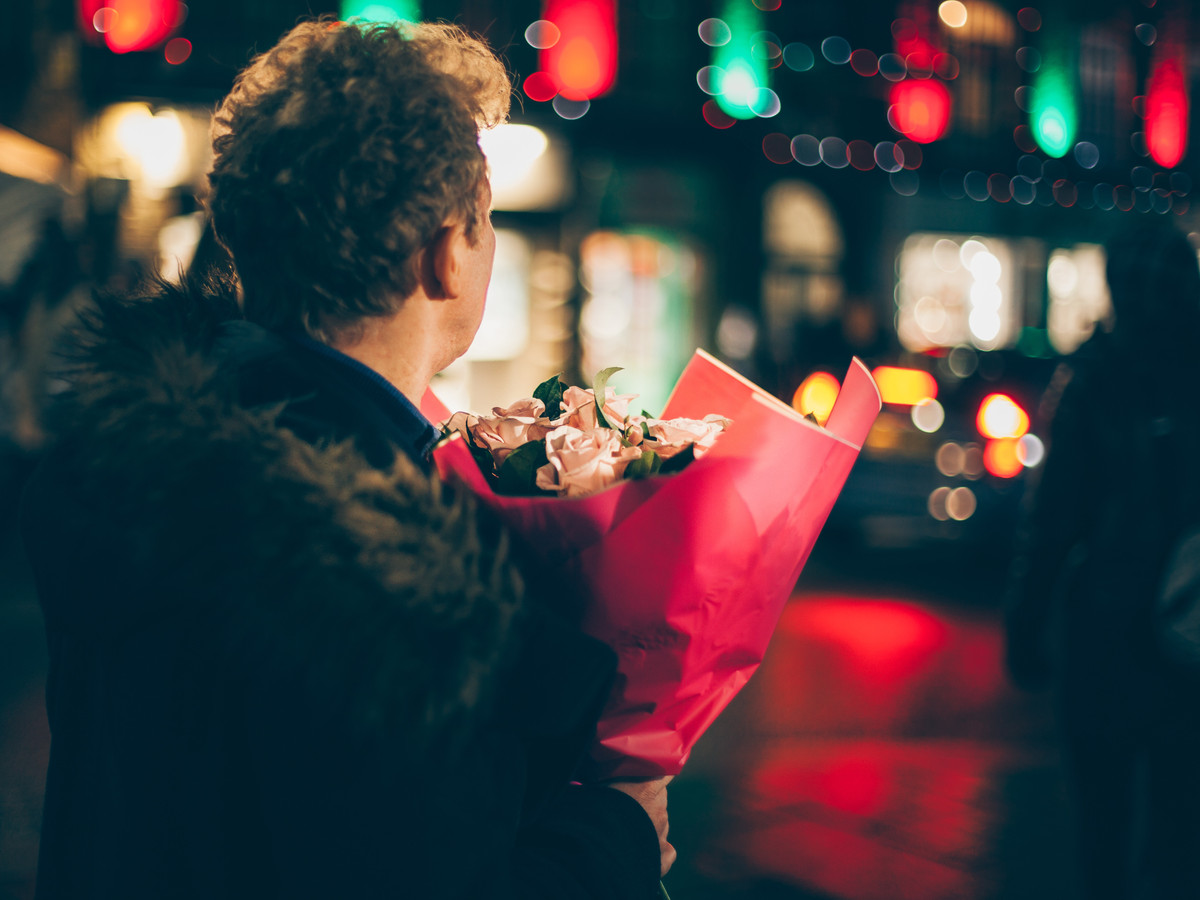 Nat Milligan - Copywriter. Man holding bunch of flowers, waiting for his date to arrive.
